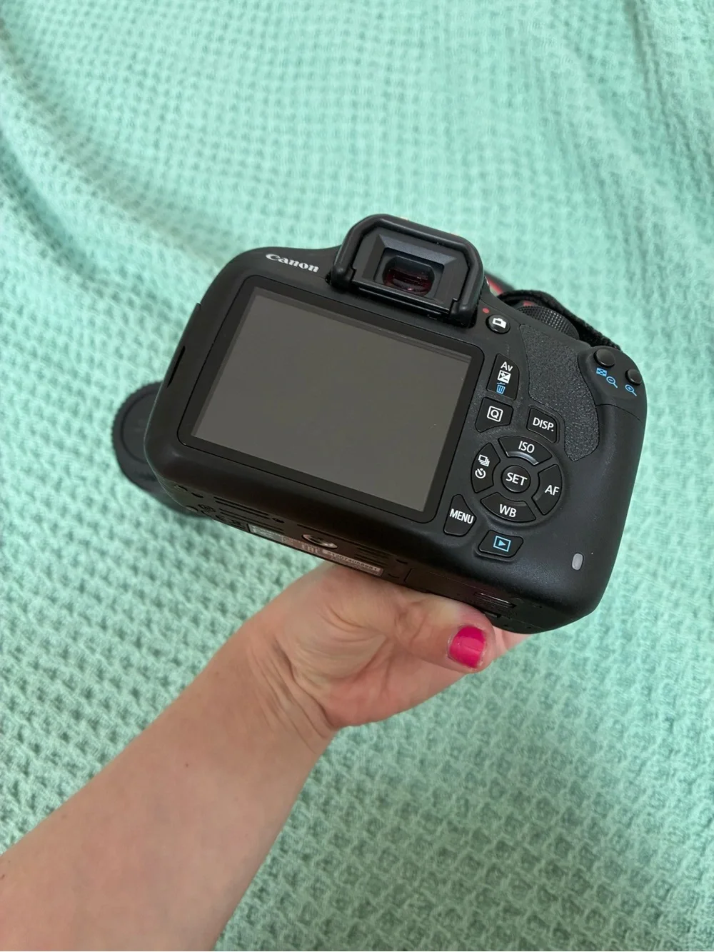 Canon DSLR Camera Body in Black with Red Strap Accents and kit lens.